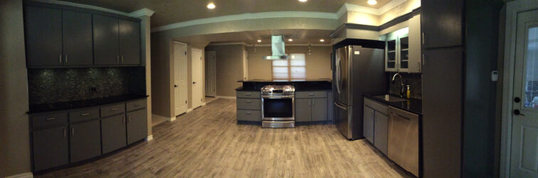 large remodeled kitchen with black and stainless steel appliances and cabinets